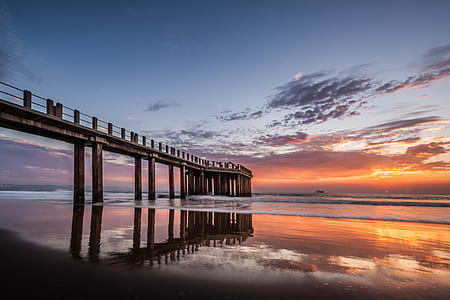 concrete bridge on body of water during sunset thumbnail