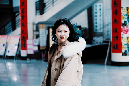 woman wearing coat standing inside building thumbnail