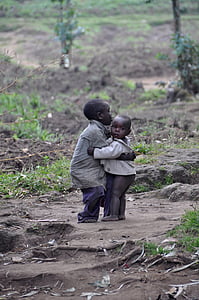 boy wearing brown jacket carrying baby during daytime thumbnail
