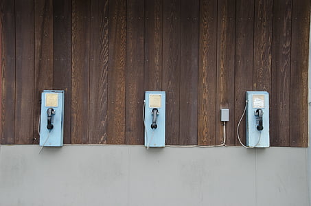 three blue telephones on wall thumbnail