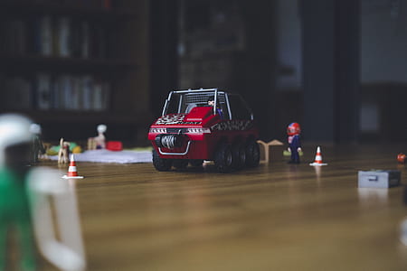 tilt shift lens photography of red and gray car on brown wooden surface thumbnail