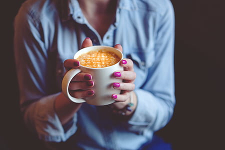 person in blue dress shirt holding a ceramic mug thumbnail