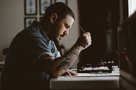 man sitting leaning on table inside room thumbnail