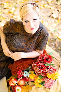 woman lying on shawl with flower arrangement and fruits thumbnail