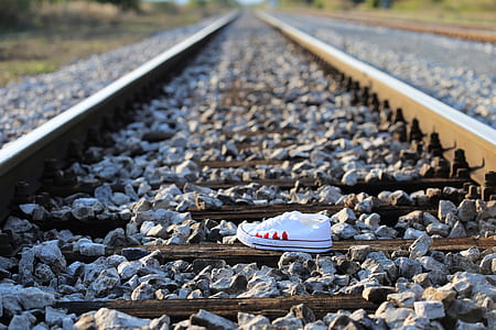 unpaired sneaker on train railing thumbnail