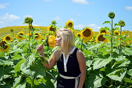 woman standing beside sunflowers thumbnail