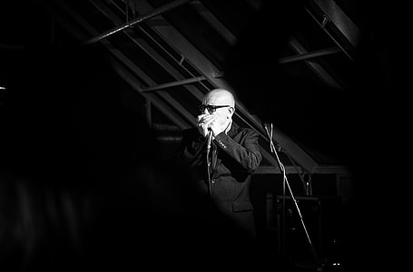 man wearing black suit jacket while holding microphone thumbnail