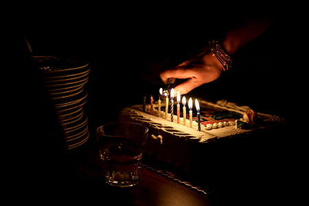 closeup photo of person lighting cake candle on table thumbnail