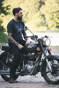 man riding black Royal Enfield motorcycle thumbnail