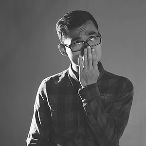 greyscale of photo of man with hand on his mouth thumbnail