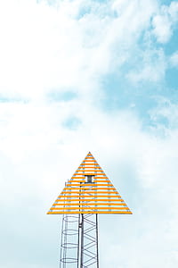 brown wooden triangle on black metal tower under blue clear sky thumbnail