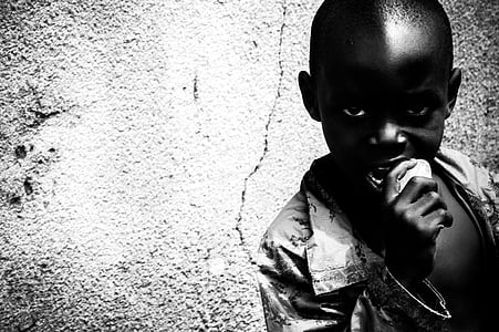 gray scale photo of boy in gray top holding gray substance thumbnail