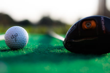 selective focus photography of black golf club and white golf ball thumbnail