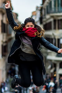 woman wearing jacket and pants jump up in air thumbnail