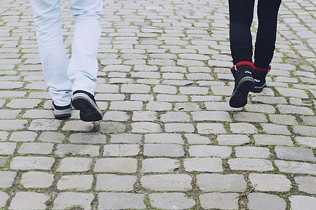 two person wearing white and black pants and sneakers walking on pavement thumbnail