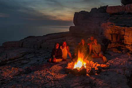 two men and three women sitting on front of campfire thumbnail