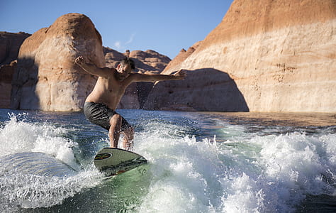 man performing surfing during daytime thumbnail