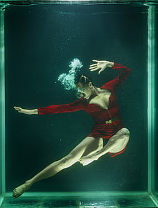 underwater photography of woman wearing red zip-up bodysuit thumbnail