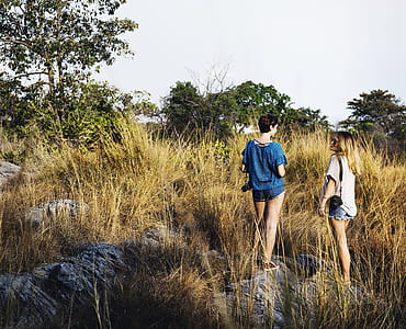 two women standing on brown field thumbnail