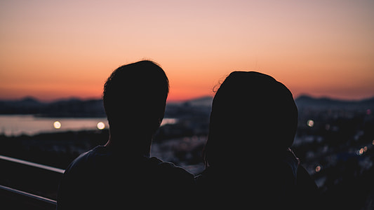 man and woman on balcony in silhouette shot thumbnail