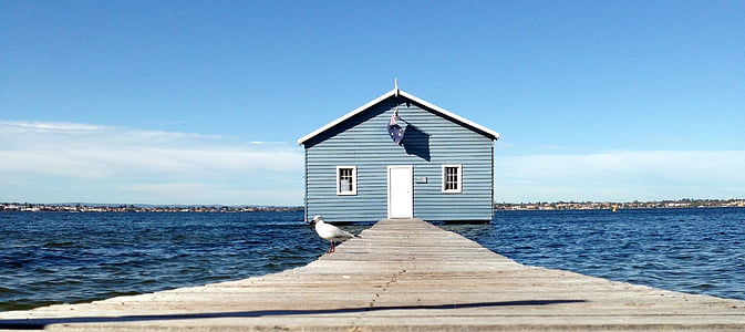 blue wooden house on sea near dock thumbnail