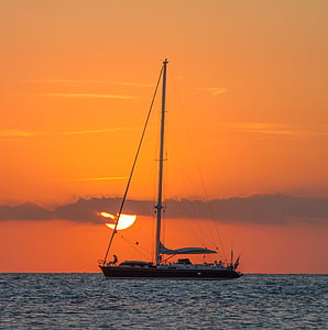 sailing boat on body of water during golden hour thumbnail