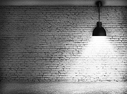 pendant lamp in front of brick wall in grayscale photography thumbnail