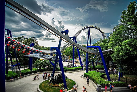 people walking under roller coaster in park thumbnail