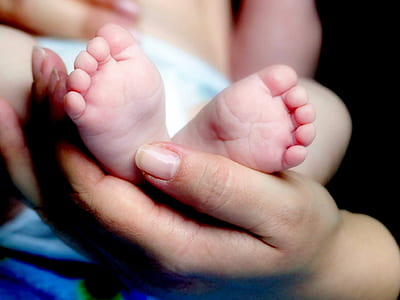person holds baby on hand thumbnail