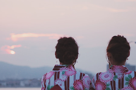 two women's wearing pink floral print blouses thumbnail