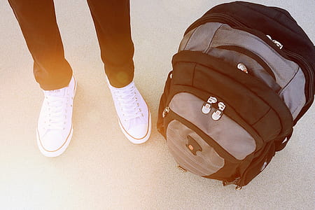 person standing beside black and gray backpack thumbnail