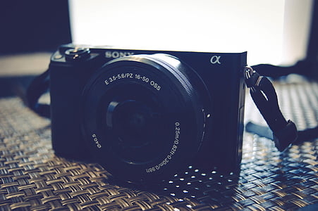 black Sony DSLR camera on grey woven surface thumbnail