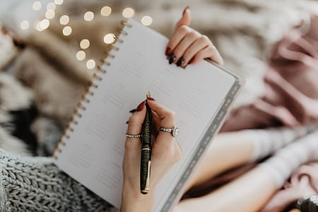 Writing in a notebook lying in bed, with coffee, candles, and gingerbreads thumbnail