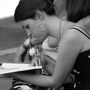 grayscale photo of woman with white book thumbnail