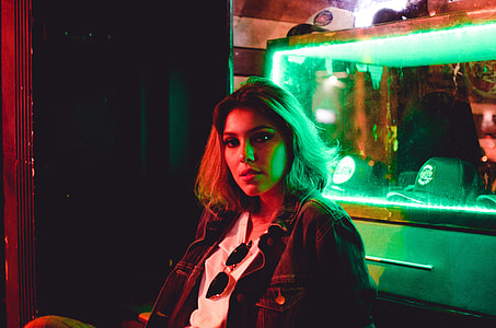woman in denim jacket near glass aquarium photo thumbnail
