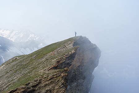 man standing on mountain edge covered by fogs thumbnail
