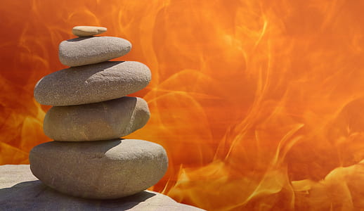 gray cairn stones with orange and yellow flames background digital wallpaper thumbnail