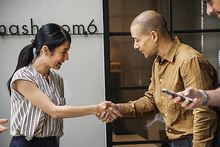 Man and Woman Handshaking Near Window thumbnail