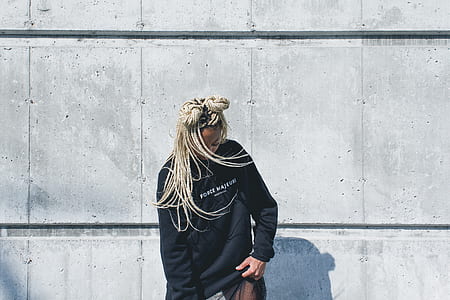woman wearing black long-sleeved shirt standing beside grey concrete wall thumbnail