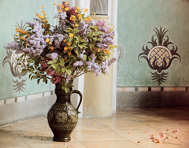 assorted flowers arrangement on vase near wall on ceramic floor thumbnail