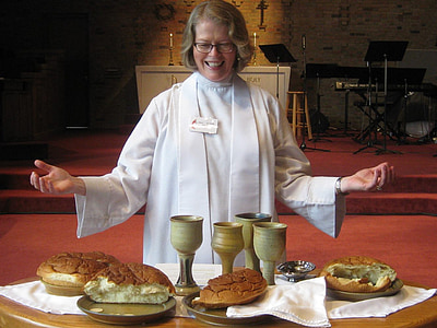 priest standing in front of chalice and leavened breads thumbnail