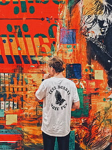 photo of man wearing shirt doing artwork on wall thumbnail