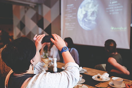 person holding smartphone taking photo of earth on wall thumbnail
