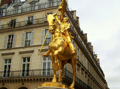 person riding horse gold statue near white building thumbnail