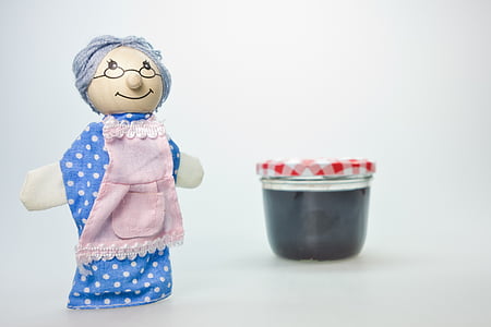 grandma doll beside clear glass container thumbnail