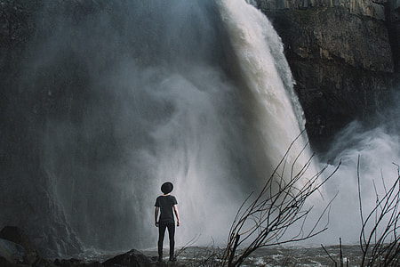 boy standing near waterfalls thumbnail