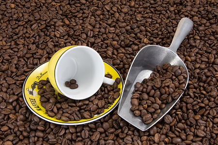 yellow and white ceramic mug on plate with coffee beans thumbnail