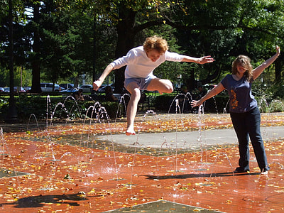 two women standing on water fountain thumbnail