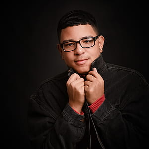man in black denim jacket and wearing eyeglasses thumbnail