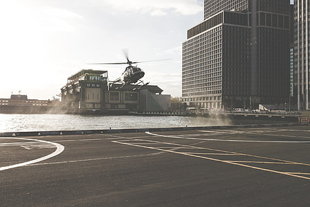 gray helicopter near high-rise building at daytime thumbnail